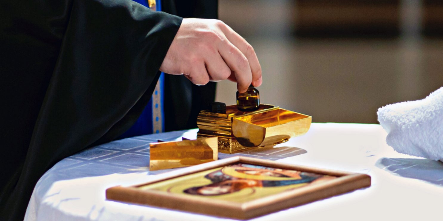 Priest using oils on an alter by a picture of Jesus - Soulshine's Anointing Oil Section