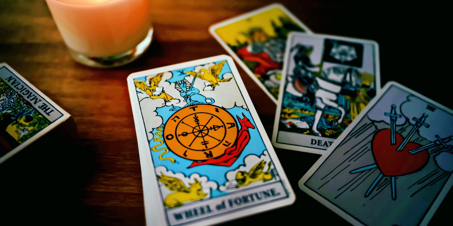 Oracle cards on a candle lit desk - Soulshine's Tarot and Oracle Cards Section